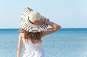 femme à la plage avec chapeau